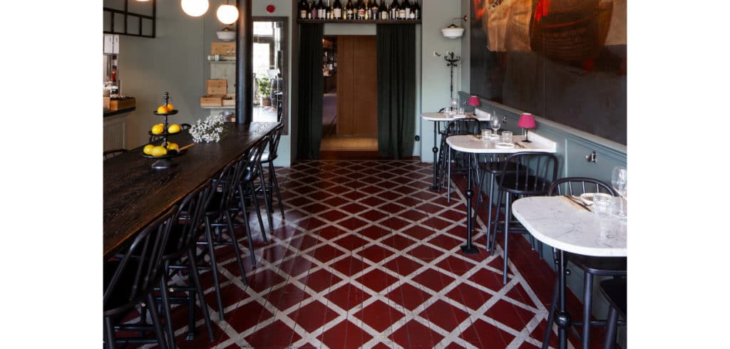 Golvtrender 2024 Färgstarkt, rustikt, hållbart och återbrukat är årets trender och har samlats här i ett golv. Istället för att lägga nytt när ytor slogs ihop målade man golven i ett enhetligt mönster. Bild Almedalsgolv.