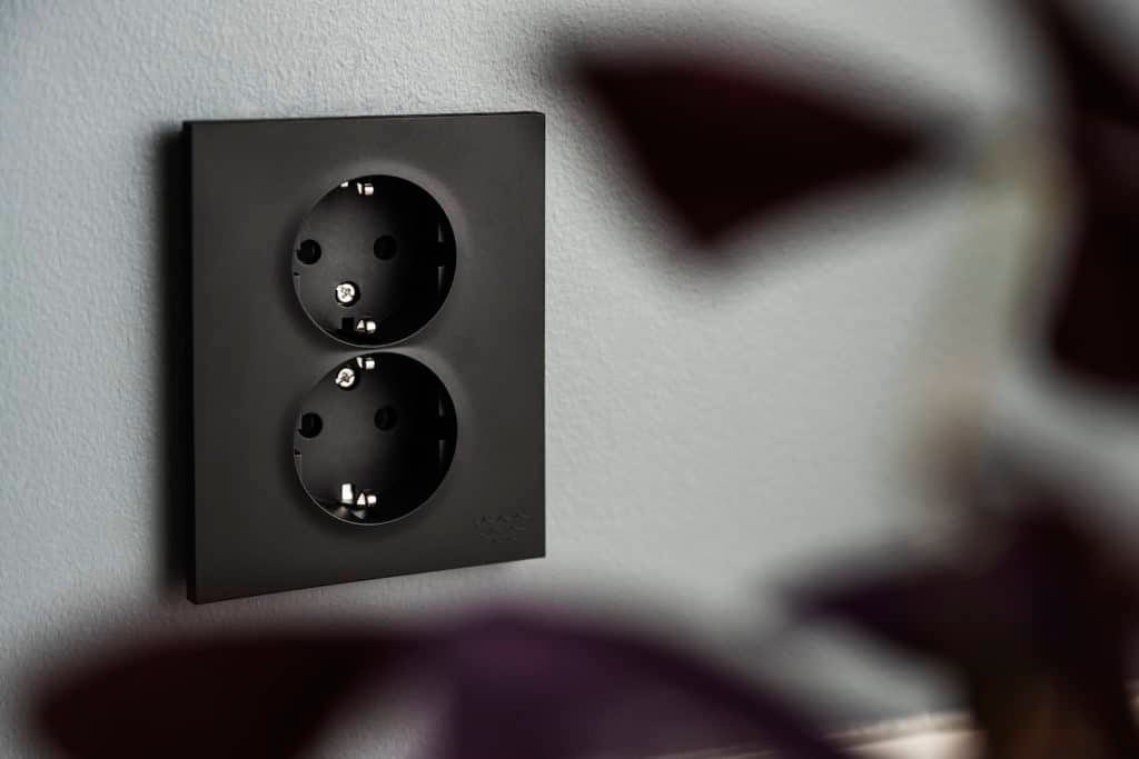 Svart vägguttag i produktserien ELKO Plus Ocean Plastic