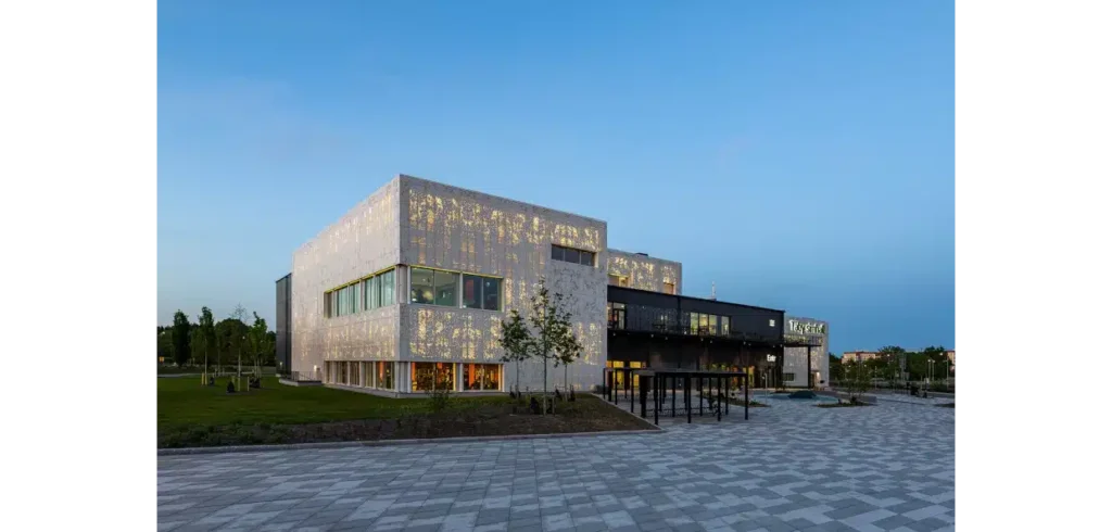 Effektfullt med perforerade fasadkassetter I mörkret skimrar Täbys nya simhall som en ädelsten.